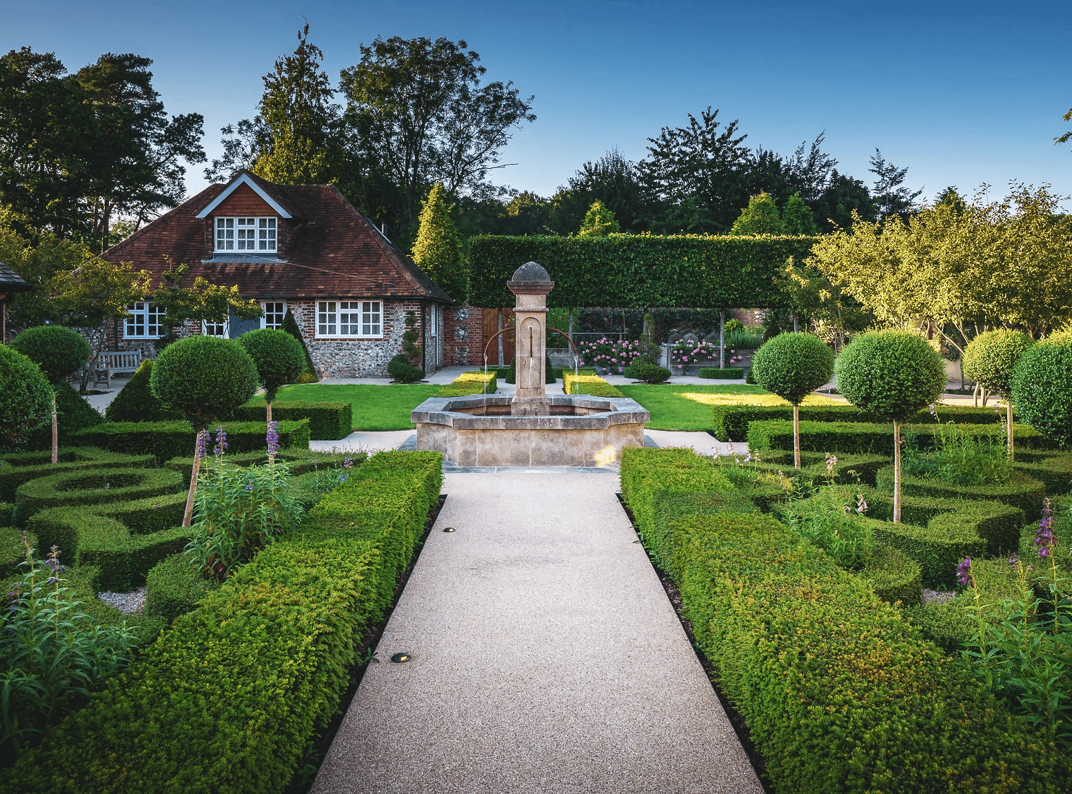 A carefully shaped garden of boxwood mounds and wildflower planting
